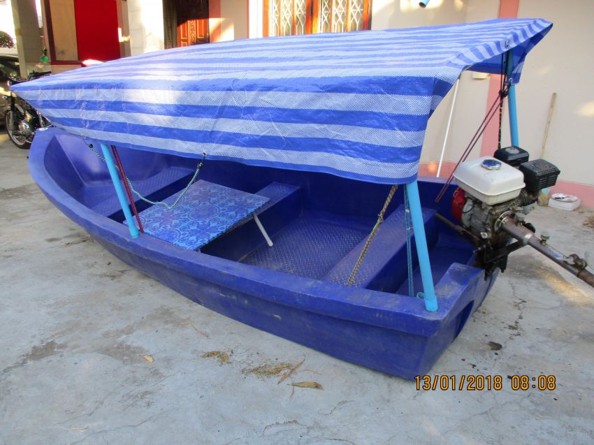 Small plastic/polyethylene boat with canopy and some