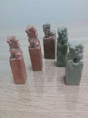 A collection of five soapstone seals in the form of foo dogs