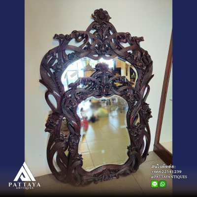 A pair of heavily carved mahogany Art Nouveau bevelled edged mirrors